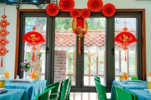 um restaurante com mesas azuis e guarda-sóis de papel vermelho em Mai Mountain Homestay em Ninh Binh