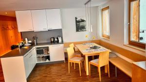 a kitchen with a table and chairs in a room at Adventure Panorama "Salober" Top 9 in Warth am Arlberg