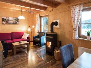 a living room with a couch and a wood stove at Almrausch Lodge Grohmann in Turracher Hohe