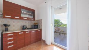 a kitchen with wooden cabinets and a balcony with a table at La Vita è Bella in Peroj