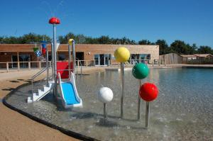 um parque infantil com escorrega e bolas na água em Chalet site naturel proche lac, 20 mn des plages Vendee - 6 pers em La Chapelle-Hermier