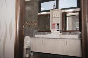 uma casa de banho com um lavatório e um espelho em Mara Meguarra Sanctuary em Ololaimutiek
