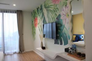 a living room with a flat screen tv on a wall at Flamingo Hải Tiến- Thanh Hóa in Nam Khê