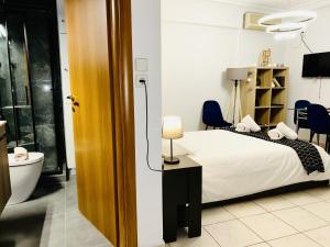 a bedroom with a bed and a bathroom with a toilet at Saronikos in Piraeus