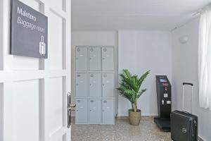 a corridor with lockers and a potted plant in a room at Suncoast Ibiza Hotel - Adults Only - in Ibiza Town