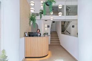 a woman standing at a reception desk in a lobby at Suncoast Ibiza Hotel - Adults Only - in Ibiza Town