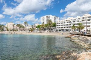 Suncoast Ibiza Hotel - Adults Only - في مدينة إيبيزا: اطلالة على شاطئ يوجد مباني في الخلف