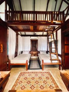 a bedroom with two bunk beds and a rug at Svarna in Udupi