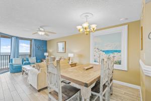 ein Esszimmer und ein Wohnzimmer mit Tisch und Stühlen in der Unterkunft Phoenix V Unit 816 in Orange Beach