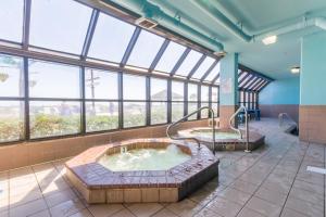 ein Whirlpool in einem großen Raum mit Fenstern in der Unterkunft Phoenix V Unit 816 in Orange Beach