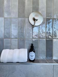 - un comptoir de salle de bains avec un rouleau de papier toilette et une bouteille de savon dans l'établissement Sneeukop Mountain Cottage, à Paarl