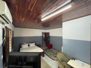 - une chambre avec un lit et un bureau dans l'établissement Couba Club, à Douala