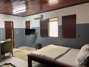 sypialnia z łóżkiem, telewizorem i oknem w obiekcie Couba Club w mieście Duala