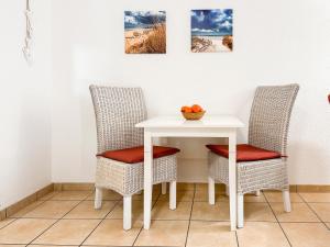 two chairs and a table with a bowl of fruit on it at FeWo StrandDomicil21 in Dahme