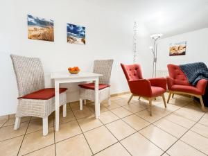 a dining room with chairs and a white table at FeWo StrandDomicil21 in Dahme +9 photos