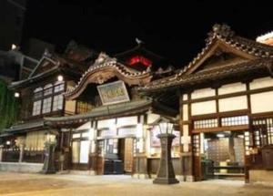 a building with a sign on top of it at night at Sky Hotel in Matsuyama