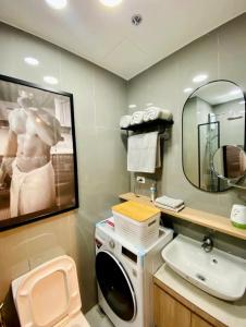 a bathroom with a washing machine and a sink at Muji-Inspired hōme-tél in the heart of Makati in Manila