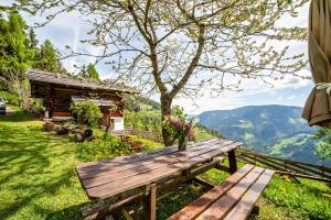 eine Holzbank auf einem grünen Feld in der Unterkunft Ferienhaus Rauchegg - Seeblick in St. Pankraz