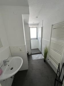 y baño blanco con lavabo y ducha. en BM01 bis BM04 Schöne Apartments in Frechen, en Frechen