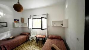 a bedroom with a bed and a table and a window at Casa Christine in Playa Migjorn