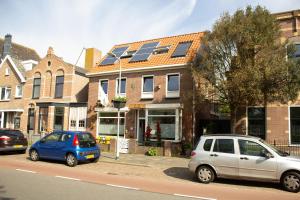 dos autos estacionados al lado de una calle en Villa La Vida, en Egmond aan Zee
