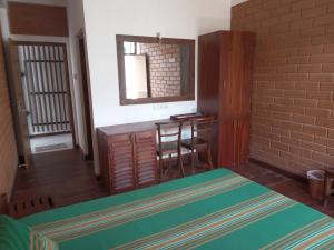 Habitación con cama, mesa y espejo. en Windy Hanthana, en Kandy