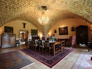 a dining room and living room with a table and chairs at Le Moulin Rénové in La Boulaye