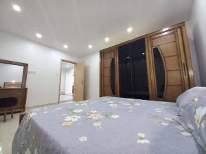 ein Schlafzimmer mit einem Bett mit einer blauen Decke mit Blumen in der Unterkunft Appartement vu sur mer, in Kolea