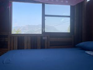 a bedroom with a bed and a large window at Bao Lac Homestay Hostel & Coffee in Bảo Lạc