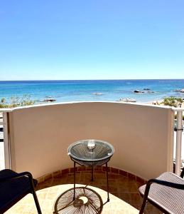 a table on a balcony with a view of the beach at Stegna Sea & Sun in Archangelos