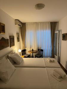 een hotelkamer met 2 bedden en een tafel bij Guest House Amfora in Budva