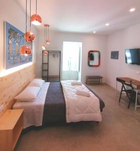 1 dormitorio con 1 cama grande y escritorio en B&B Ibla Art Centro, en Ragusa
