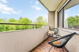 a balcony with two chairs and a large window at IDYL kostenloser Privat-Parkplatz Wifi SmartTV Balkon in Ludwigsburg