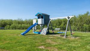 a playground with a blue slide in a field at Apartamenty Sun & Snow Na Różanej in Sianozety