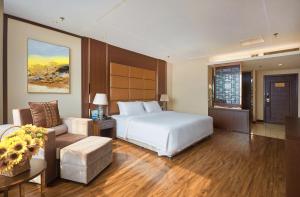 um quarto de hotel com uma cama e um sofá em Beijing Sunflower Hotel em Tongzhou