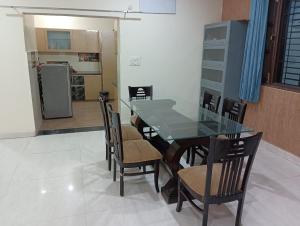 a dining room with a glass table and chairs at Osho home stay in Lucknow