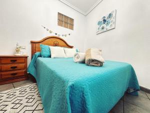 a bedroom with a bed with a blue blanket at Apartamento LA PLAZA in Bogarra