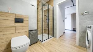 a bathroom with a toilet and a shower at Apartamenty Sun & Snow Na Różanej in Sianozety