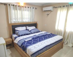 AbeokutaInviting 2-Bed House in Abeokuta的卧室里有一张床，床单和枕头都是蓝色的