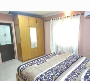 AbeokutaInviting 2-Bed House in Abeokuta的一间带床、柜子和窗户的卧室