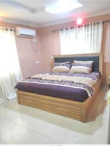 duże łóżko w pokoju z oknem w obiekcie Inviting 2-Bed House in Abeokuta w mieście Abeokuta