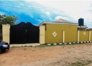 un bâtiment jaune avec une clôture noire dans l'établissement Inviting 2-Bed House in Abeokuta, à Abeokuta