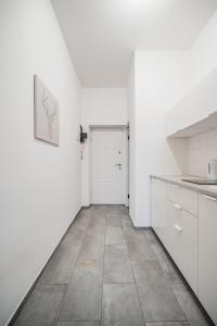 eine Küche mit weißen Wänden und Fliesenboden in der Unterkunft cute apartment in vienna in Wien