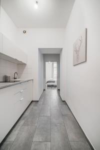 eine Küche mit weißen Schränken und Fliesenboden in der Unterkunft cute apartment in vienna in Wien