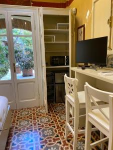 a room with a desk with a computer and chairs at Incasa Verona in Verona