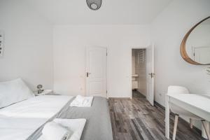 ein weißes Schlafzimmer mit einem Bett und einem Waschbecken in der Unterkunft cute apartment in vienna in Wien