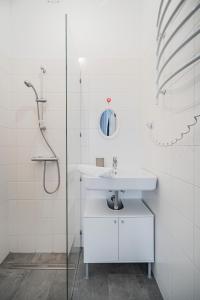 ein weißes Bad mit einem Waschbecken und einer Dusche in der Unterkunft cute apartment in vienna in Wien