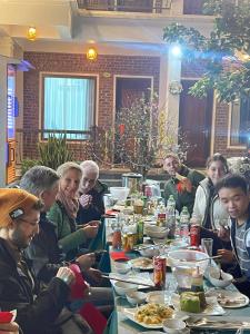 um grupo de pessoas sentadas à mesa a comer em Mai Mountain Homestay em Ninh Binh