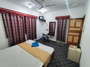 una stanza d'albergo con un letto con una busta blu sopra di Hotel New Heaven Canal a Srinagar