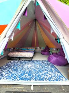 uma tenda com duas camas e um cobertor em 4 Unique Rental Tents Choose from a Bell, Cabin, or Yurt Tent All with Kitchenettes & Comfy beds NO BEDDING SUPPLIED em Narberth